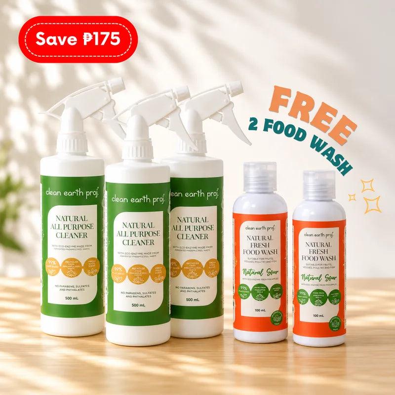Five Clean Earth natural cleaning products arranged on a light wooden surface: three 500ml white spray bottles of Natural All-Purpose Cleaner in green packaging alongside two 100ml orange bottles of Natural Fresh Food Wash
