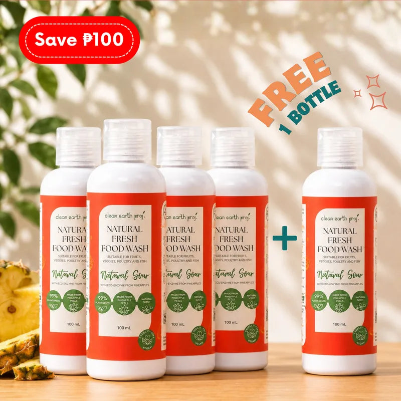 Five 100ml bottles of Clean Earth Natural Fresh Food Wash arranged on a light wooden surface in front of a tropical background